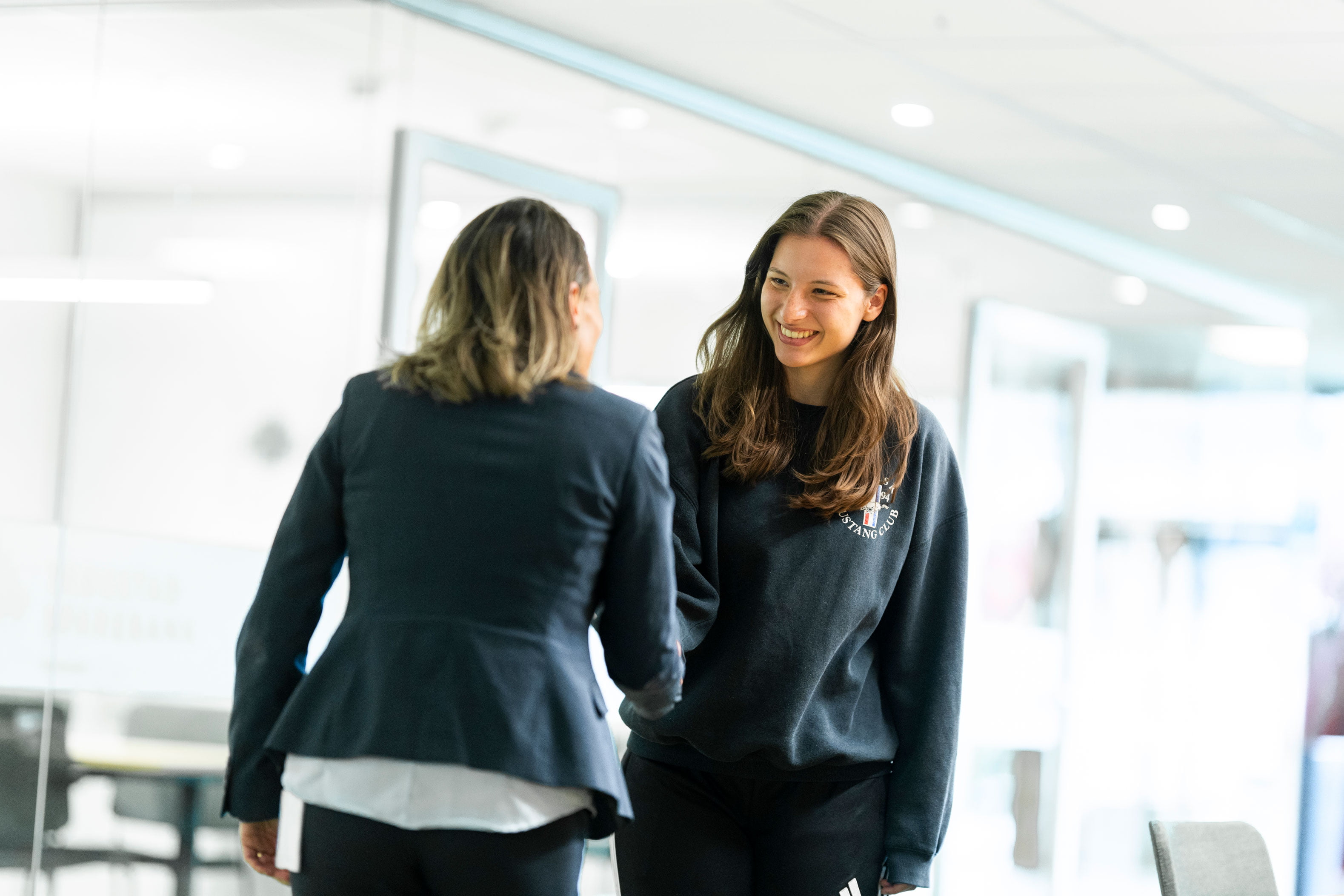 En ung jente blir møtt av en rådgiver i banken