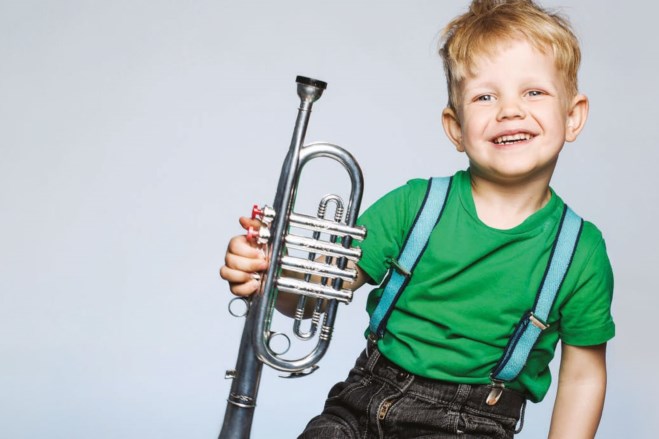 En ung gutt holder en trompet