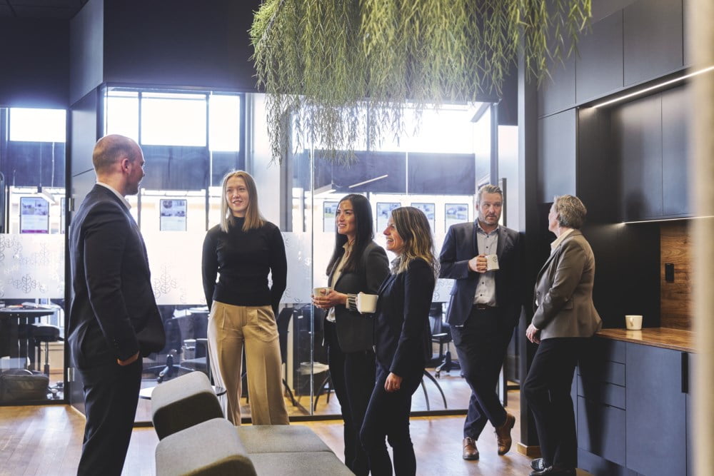 Rådgivere står og snakker sammen ved kaffemaskinen