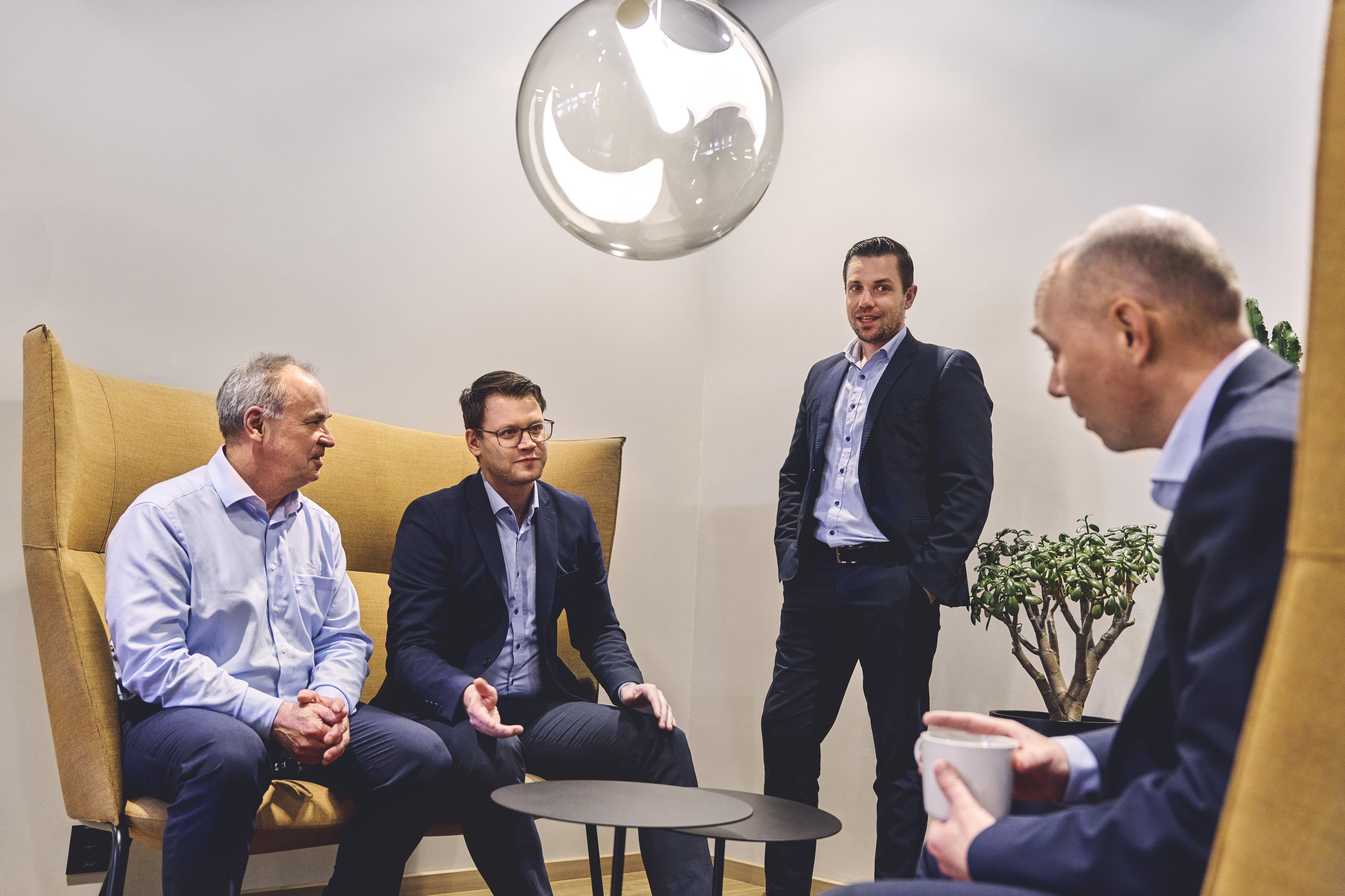 Rådgivere sitter i sofaer og snakker sammen over en kopp kaffe