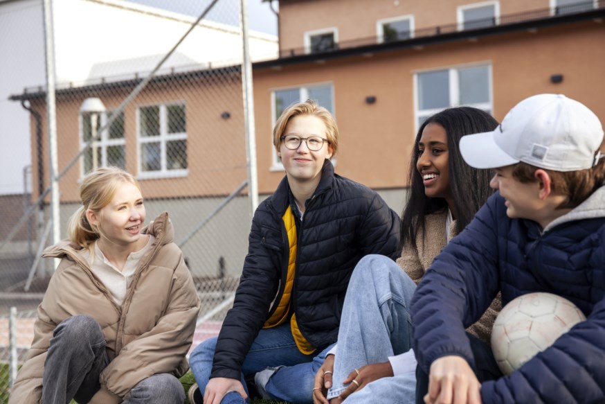 Ungdommer som sitter utenfor en skole